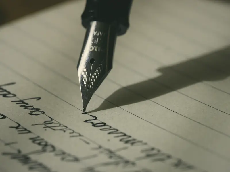 A fountain pen writing a letter by hand.